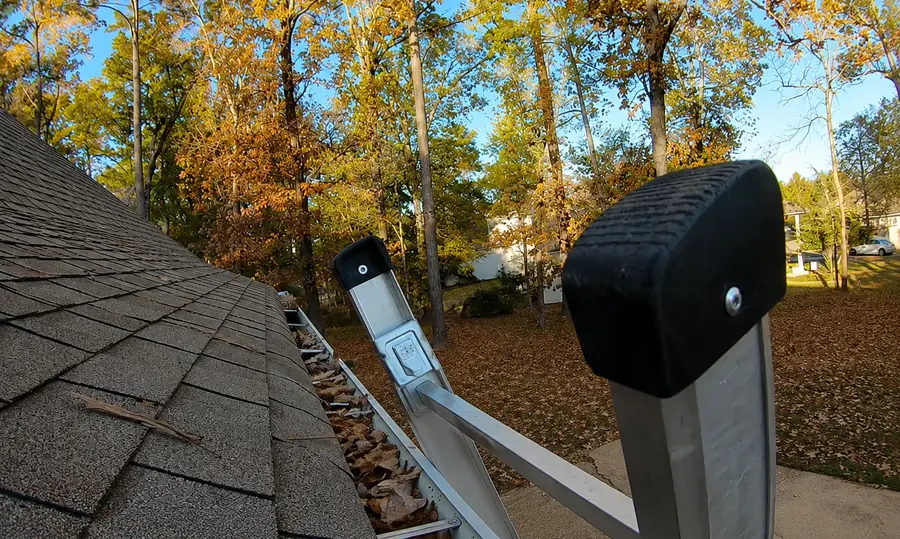 Scoop tool lifting packed debris from a gutter corner during gutter cleaning in Jacksonville FL