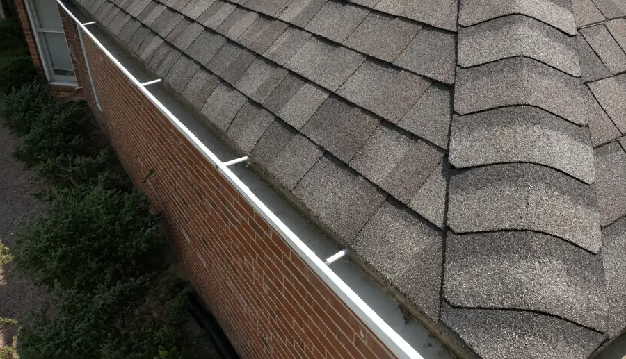 Rain-soaked pine needles clogging a gutter mouth — Jacksonville gutter cleaning